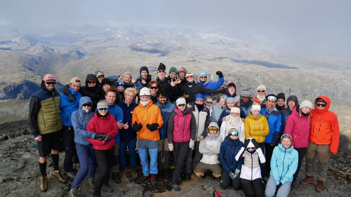 En gruppe mennesker som poserer for et bilde på et fjell